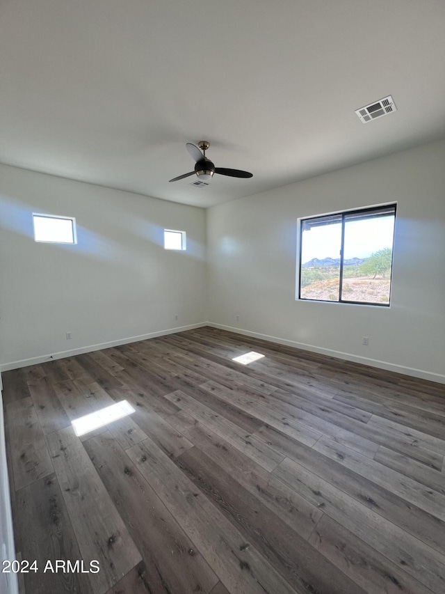 empty room featuring ceiling fan and dark wood-type flooring