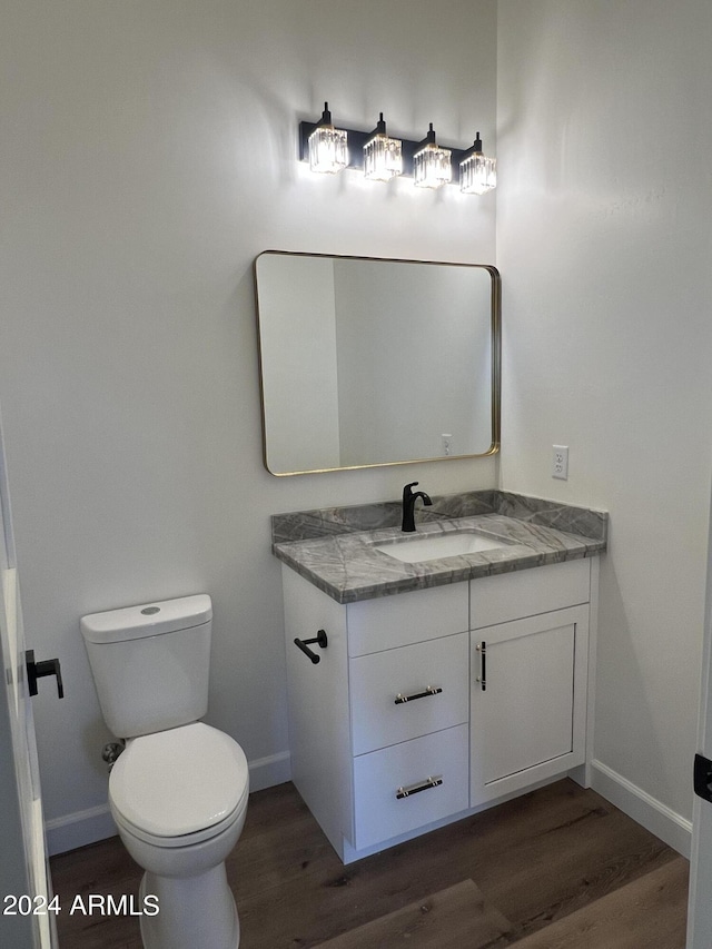 bathroom featuring toilet, vanity, and hardwood / wood-style flooring