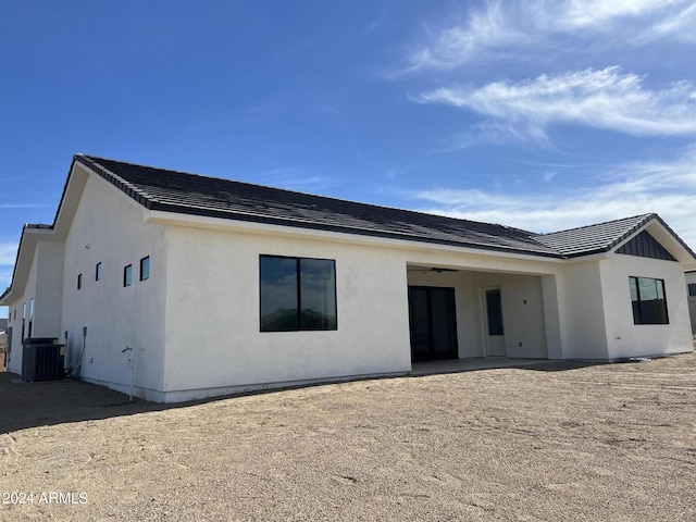 rear view of house featuring central AC unit and ceiling fan