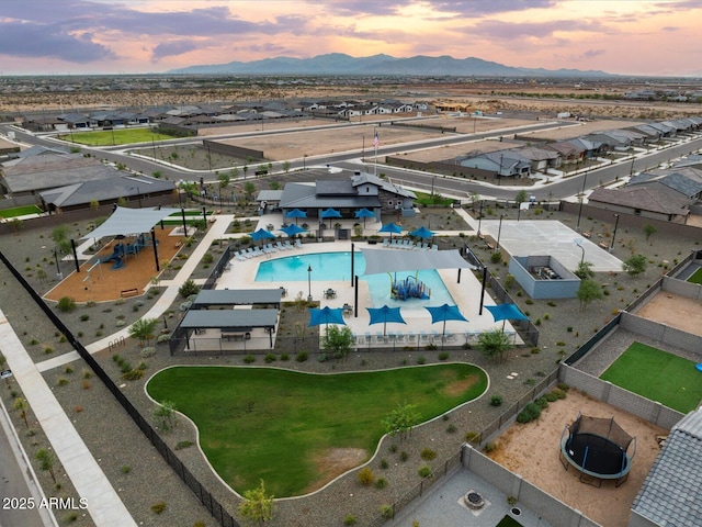 aerial view at dusk featuring a mountain view and a residential view