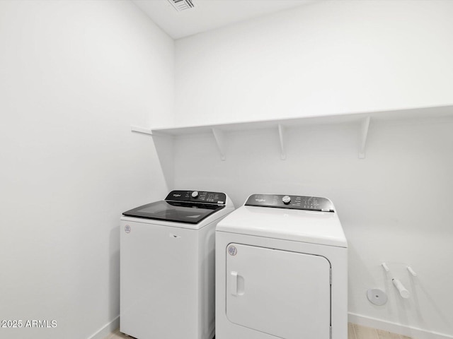 washroom with washing machine and clothes dryer, laundry area, and baseboards