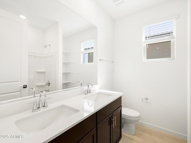 bathroom with a sink, toilet, walk in shower, and wood finished floors