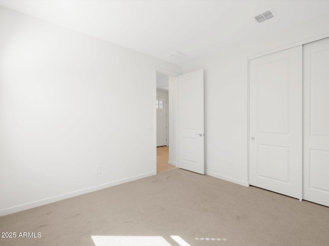 unfurnished bedroom with carpet flooring, baseboards, visible vents, and a closet