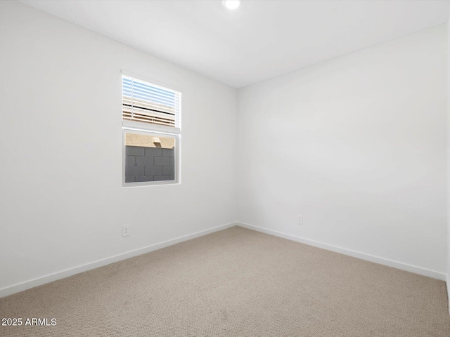 carpeted empty room featuring baseboards