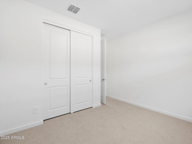 unfurnished bedroom with light carpet, visible vents, and baseboards