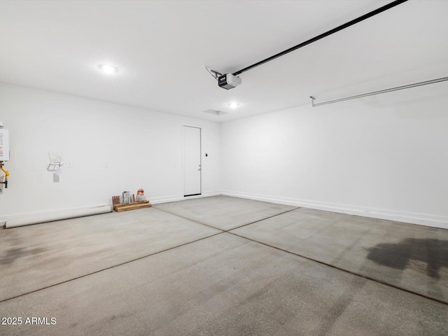 garage featuring water heater, recessed lighting, a garage door opener, and baseboards