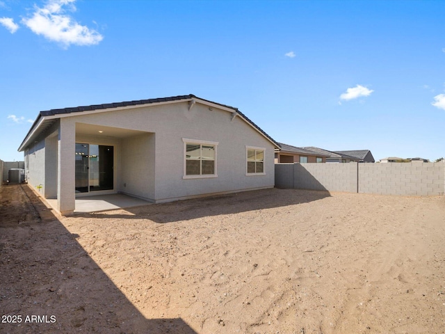 back of property with central air condition unit, stucco siding, a patio, and a fenced backyard