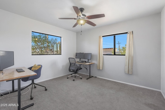 carpeted home office featuring ceiling fan