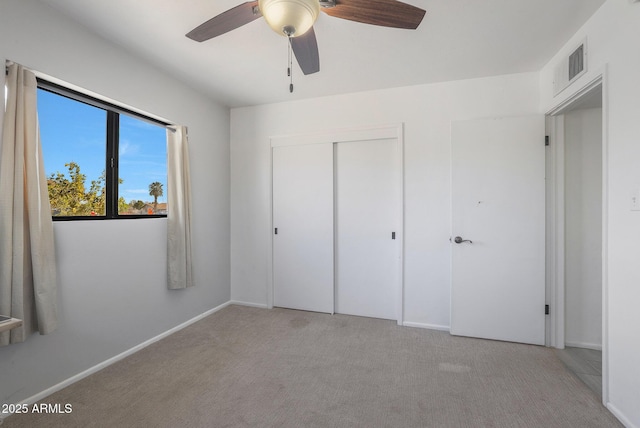 unfurnished bedroom featuring light carpet, a closet, and ceiling fan