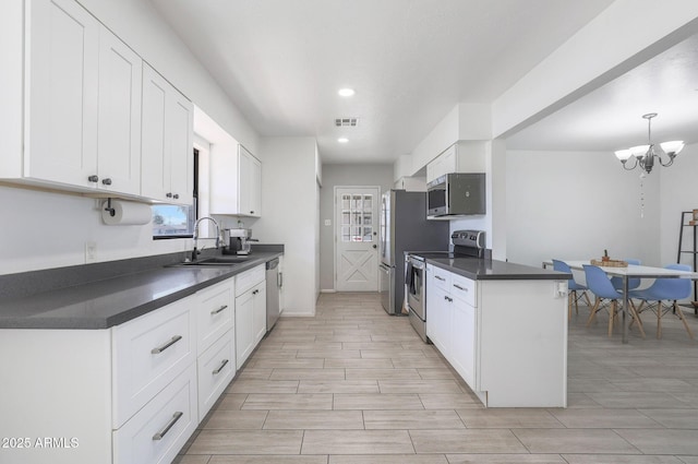 kitchen with stainless steel appliances, white cabinetry, and sink