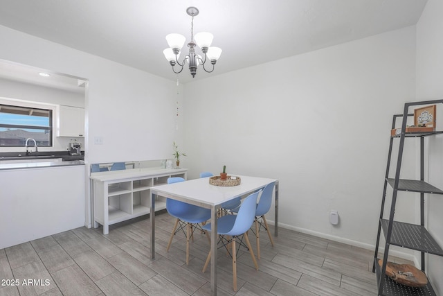 dining space featuring sink and an inviting chandelier