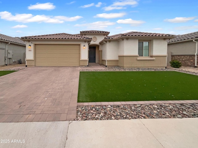 mediterranean / spanish home with stucco siding, a tile roof, decorative driveway, a front yard, and an attached garage