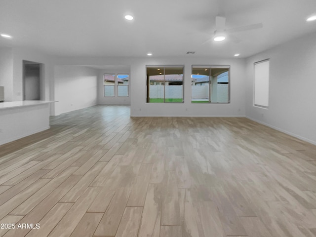 unfurnished living room with light wood finished floors, recessed lighting, baseboards, and ceiling fan