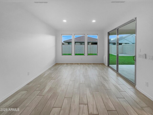 unfurnished room with recessed lighting, light wood-type flooring, and baseboards