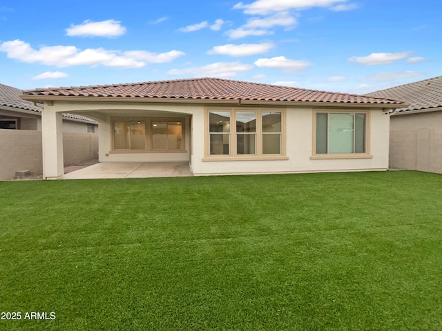 back of property with a patio, a yard, fence, and stucco siding