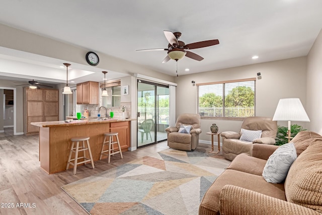 living area featuring recessed lighting, light wood-style flooring, baseboards, and a ceiling fan