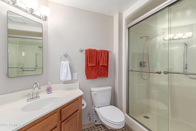 bathroom with vanity, a shower stall, and toilet