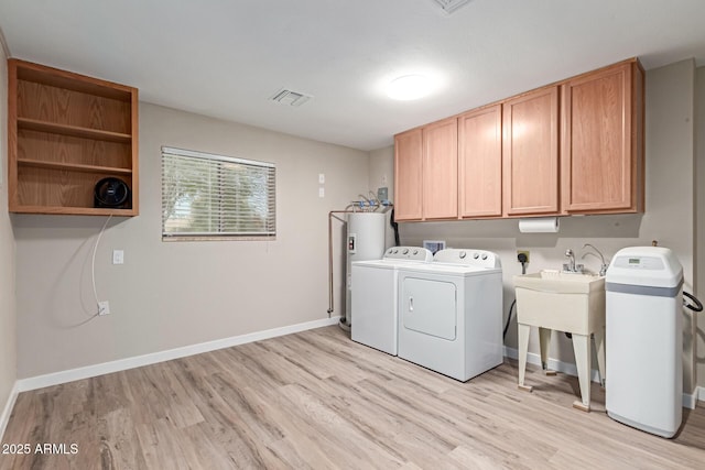 laundry room with washing machine and dryer, cabinet space, visible vents, and light wood-type flooring