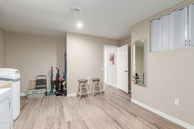 interior space with wood finished floors, visible vents, and baseboards