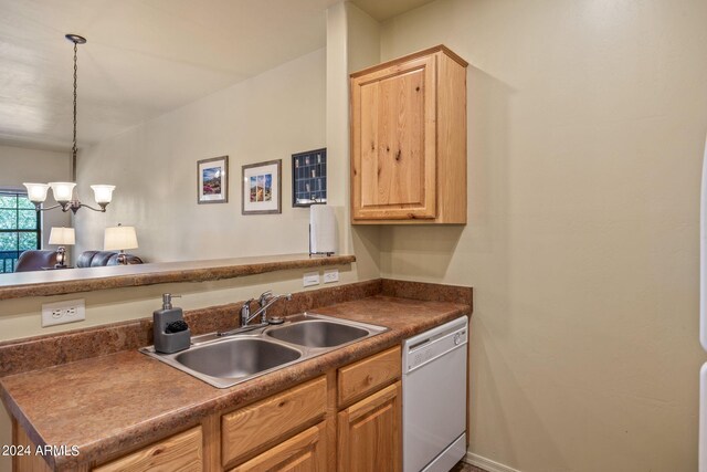 kitchen featuring sink, kitchen peninsula, decorative light fixtures, dishwasher, and a notable chandelier