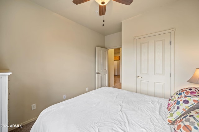 bedroom featuring white fridge, a closet, ceiling fan, and carpet floors