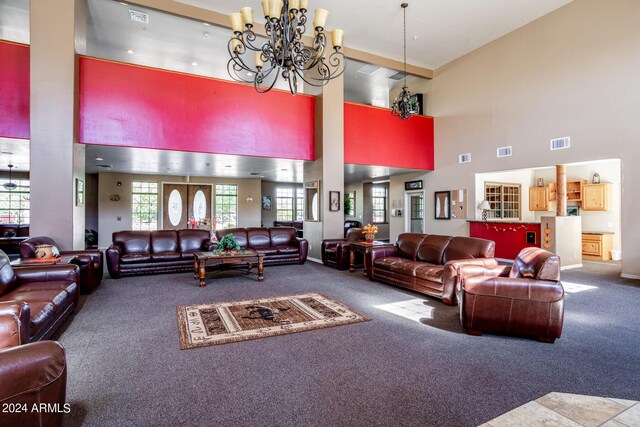 living room featuring carpet flooring, a notable chandelier, and high vaulted ceiling