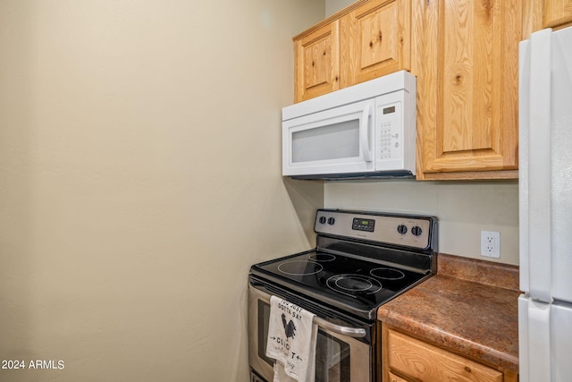 kitchen featuring light brown cabinets and white appliances