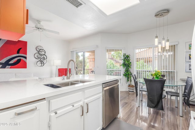 kitchen with a sink, visible vents, light countertops, light wood-type flooring, and dishwasher