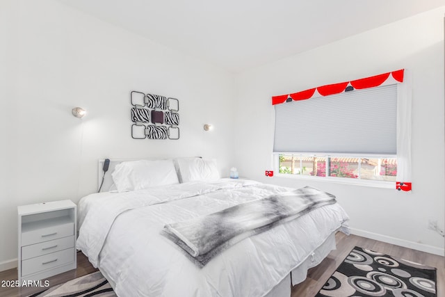 bedroom featuring baseboards and wood finished floors