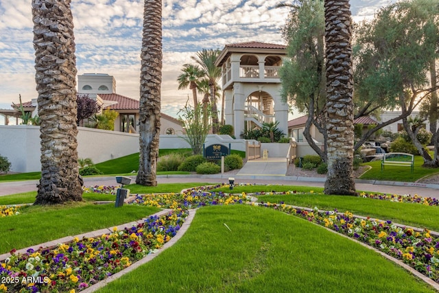 view of property's community with fence and a lawn