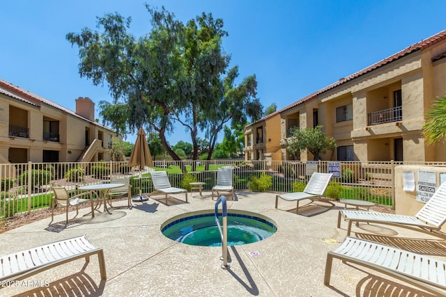 view of swimming pool with a hot tub, fence, and a patio