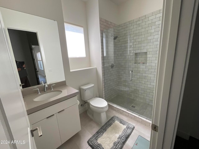 bathroom featuring vanity, tile patterned floors, toilet, and walk in shower