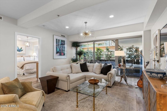 living room with an inviting chandelier and light hardwood / wood-style floors