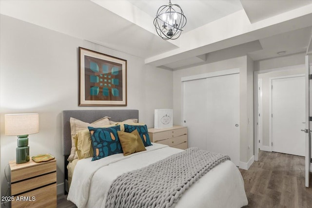 bedroom with an inviting chandelier, hardwood / wood-style floors, and a closet