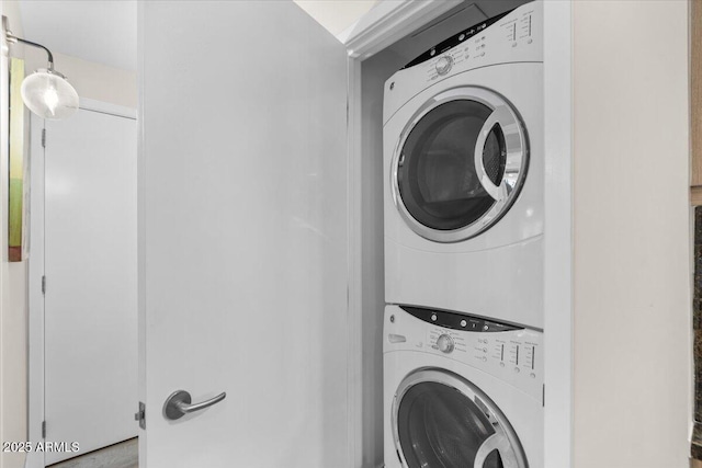 laundry room featuring stacked washer / drying machine