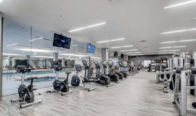 workout area with light hardwood / wood-style floors