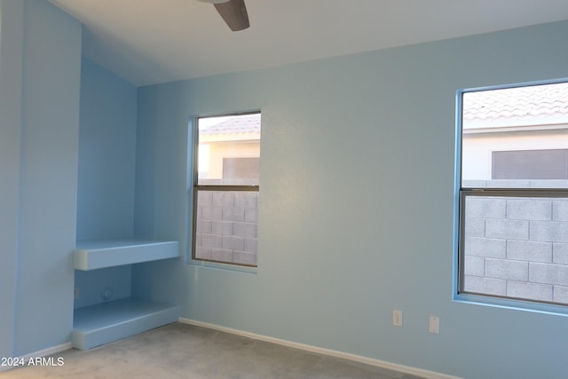 carpeted spare room featuring ceiling fan