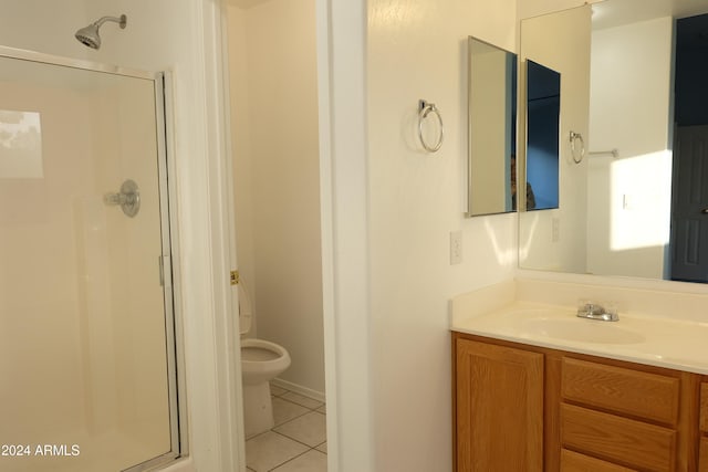 bathroom featuring tile patterned floors, vanity, a shower with shower door, and toilet