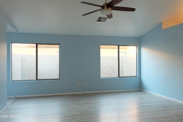 empty room featuring wood-type flooring, vaulted ceiling, and ceiling fan