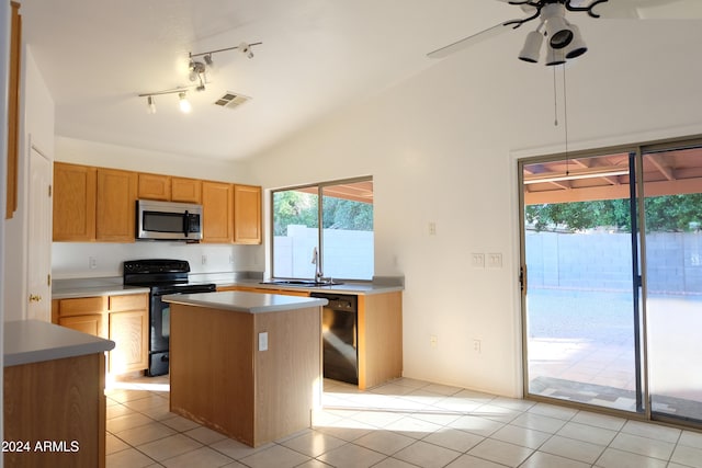 kitchen with vaulted ceiling, ceiling fan, sink, black appliances, and a kitchen island