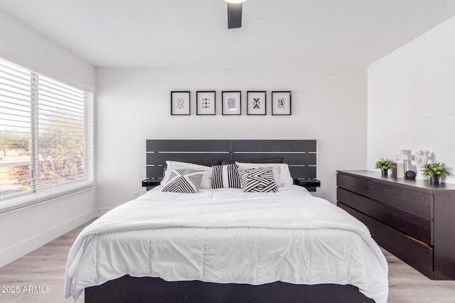 bedroom featuring multiple windows, ceiling fan, and light hardwood / wood-style flooring