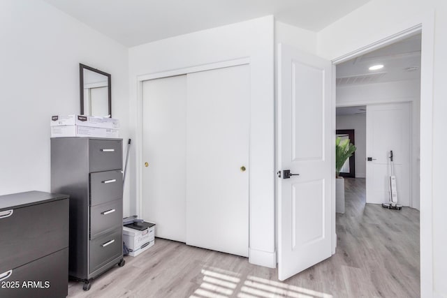 bedroom featuring light hardwood / wood-style flooring and a closet