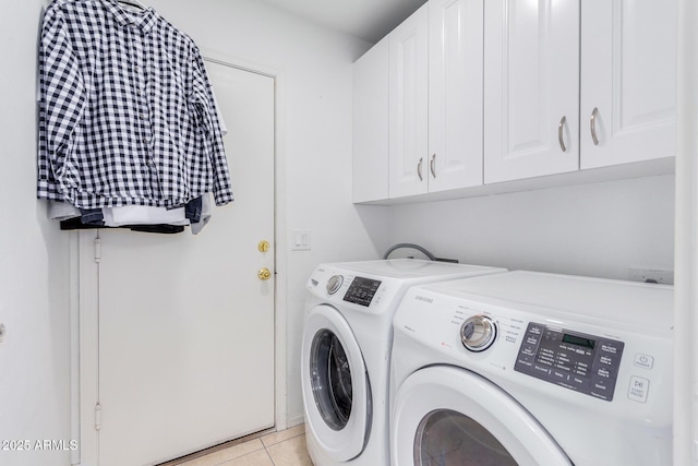 washroom with cabinets, light tile patterned floors, and washing machine and clothes dryer