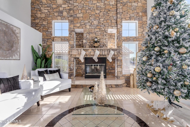 tiled living room featuring a stone fireplace