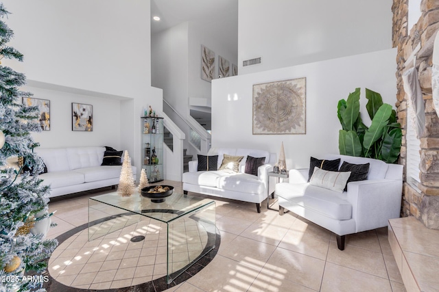 living room featuring a towering ceiling and light tile patterned floors