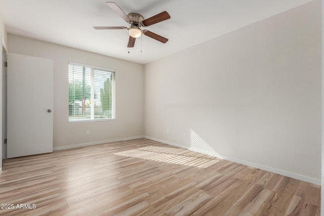 spare room featuring baseboards, light wood finished floors, and ceiling fan