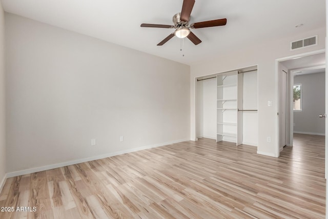 unfurnished bedroom featuring baseboards, visible vents, a closet, and light wood-type flooring