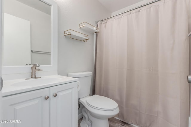 bathroom with curtained shower, toilet, wood finished floors, and vanity