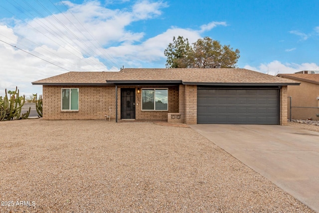 single story home with a garage, brick siding, and concrete driveway