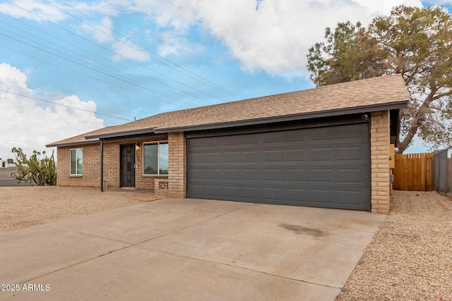 ranch-style home with brick siding, roof with shingles, an attached garage, and fence